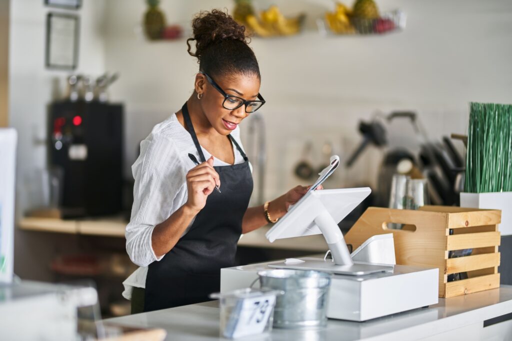 メモを見ながらPOSレジに注文を入力する店員
